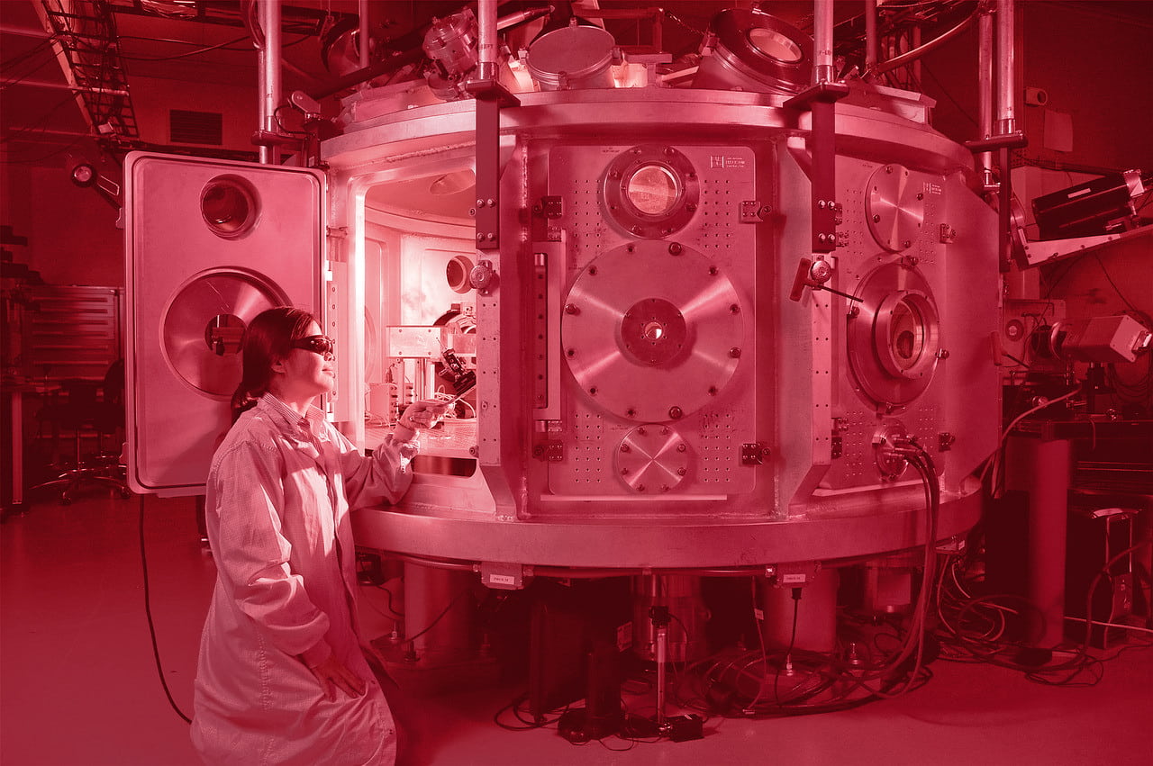 a woman scientist working on a large machine in a laboratory.