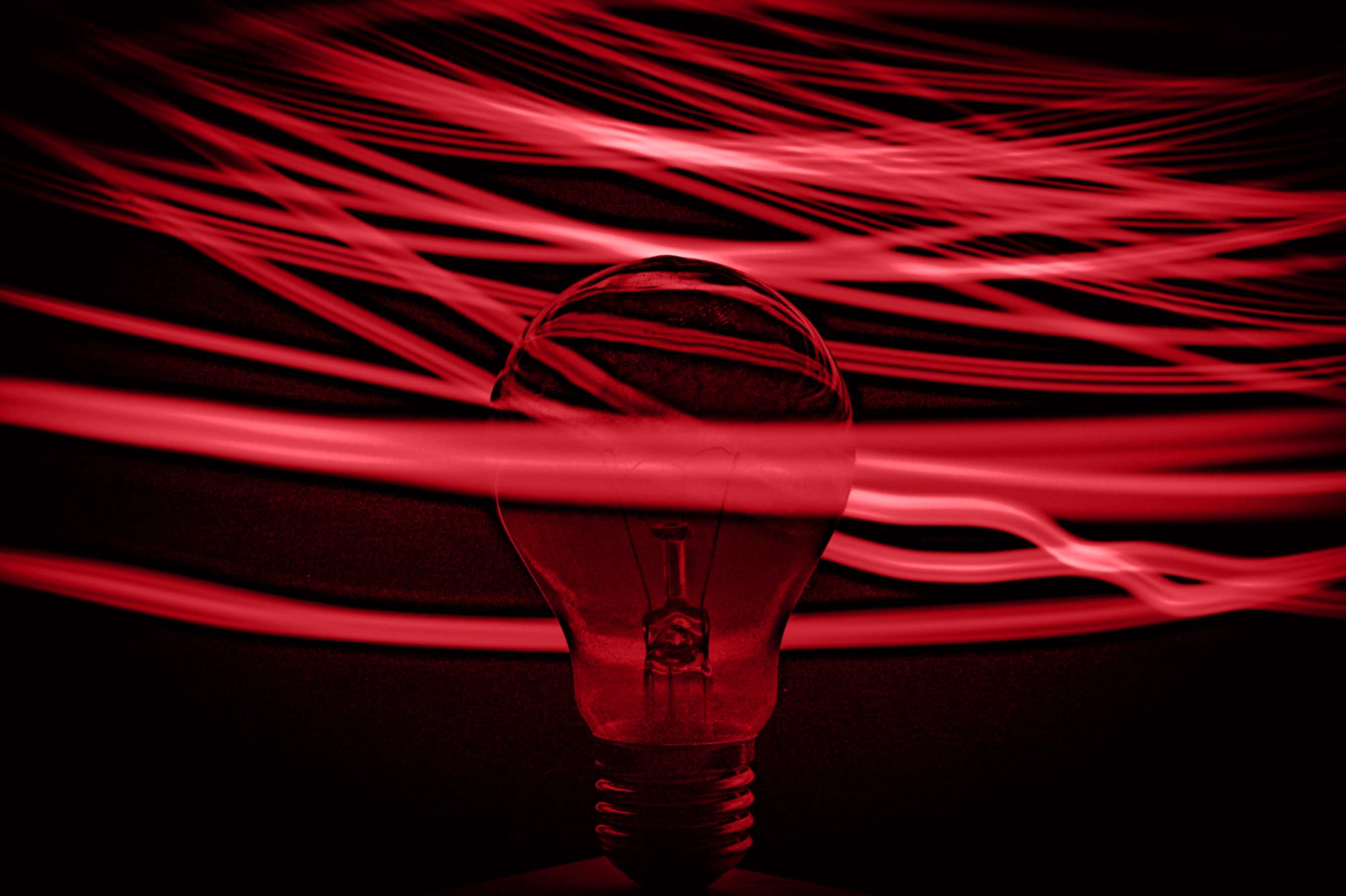 a red light bulb with light streaks radiating around it.